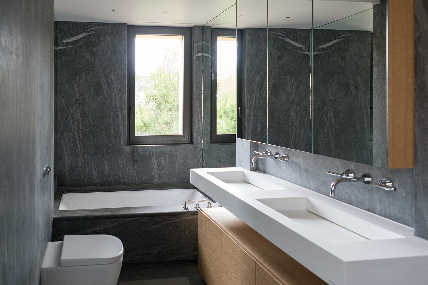 Salle de bain rénovée avec double vasque et baignoire encastrée